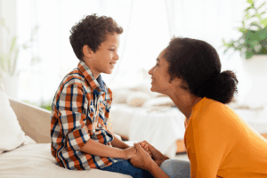 Child and mom smiling and holding hands