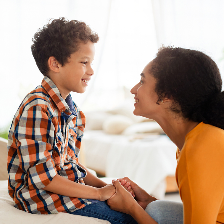 Child and mom smiling and holding hands